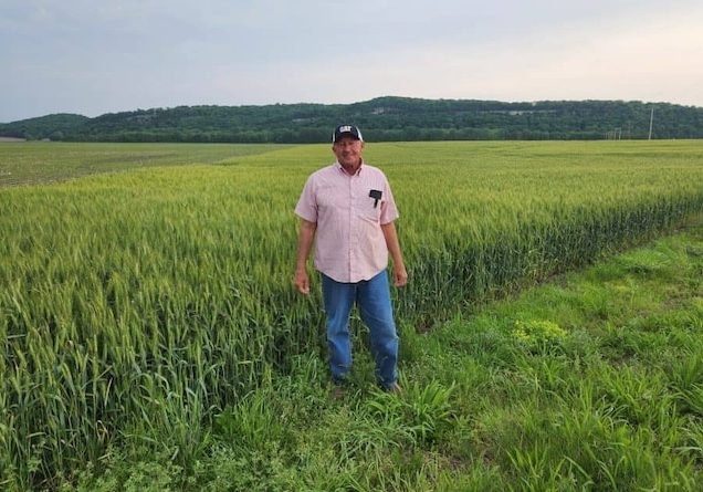 Delbert-Wittenauer-Standing-in-front-of-his-farmland-in-Monroe-County